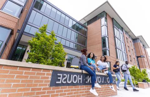 Students sitting and talking in front of Hugo Owens residence hall